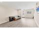 Open living room with light-colored walls, wood-look flooring, and a futon for versatile seating at 3045 Logue Rd, Myakka City, FL 34251