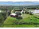 Aerial view of red barn with lush green land and pond in the background at 3045 Logue Rd, Myakka City, FL 34251