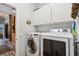 Practical laundry room with side-by-side washer and dryer and white storage cabinets at 315 36Th Ne St, Bradenton, FL 34208