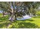 Backyard view with waterfront, mature trees, and lush green grass at 315 36Th Ne St, Bradenton, FL 34208