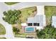 Aerial view of a charming house with a pool, solar panels and verdant landscaping, offering privacy at 3240 6Th St, Sarasota, FL 34237