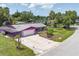 Charming single-story purple home featuring a spacious driveway, well-maintained lawn, and lush landscaping at 3240 6Th St, Sarasota, FL 34237