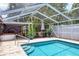 Enclosed pool area with inviting pool, patio furniture, lush landscaping, and a covered hot tub at 3240 6Th St, Sarasota, FL 34237