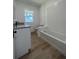 Bright bathroom featuring wood-look floors, white plank walls, tub with white subway tile, and granite countertop vanity at 3429 37Th N St, St Petersburg, FL 33713