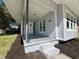 Inviting front porch featuring light gray paint, shade trees, an exterior light, and white framed windows at 3429 37Th N St, St Petersburg, FL 33713