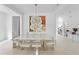 Stylish dining area with modern art, a contemporary chandelier, and a view to the stairway at 3671 Summerwind Cir, Bradenton, FL 34209