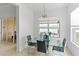 Bright dining area featuring a glass table, modern chandelier, and a scenic waterfront view through the window at 3671 Summerwind Cir, Bradenton, FL 34209