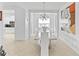 Formal dining area with an elegant chandelier and modern art, adjacent to a well-equipped kitchen at 3671 Summerwind Cir, Bradenton, FL 34209