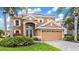 This elegant two-story home features a tile roof, an arched entry, and a two-car garage with beautiful landscaping at 3671 Summerwind Cir, Bradenton, FL 34209