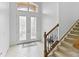 Bright foyer with tile flooring, staircase, and decorative glass double doors leading to the home's entry at 3671 Summerwind Cir, Bradenton, FL 34209