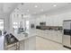 Modern kitchen featuring white cabinetry, a stone backsplash, a quartz countertop, and a large island with seating at 3671 Summerwind Cir, Bradenton, FL 34209