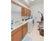Functional laundry room with washer, dryer, sink, cabinets, and hanging rack at 3671 Summerwind Cir, Bradenton, FL 34209