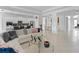 Open-concept living room with tile floors, white walls, and an adjacent kitchen and dining area at 3671 Summerwind Cir, Bradenton, FL 34209
