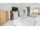 Bright main bedroom featuring a TV, walk-in closet, modern furnishings, and a luxurious, comfortable bed at 3671 Summerwind Cir, Bradenton, FL 34209