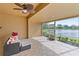 Covered patio area showcasing tiled flooring, outdoor seating, and screened windows overlooking water views at 3671 Summerwind Cir, Bradenton, FL 34209