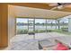 Outdoor patio featuring tiled floors and screened windows with views of the backyard and community lake at 3671 Summerwind Cir, Bradenton, FL 34209