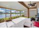 Screened lanai overlooking serene water views with decorative tile flooring, a ceiling fan, and patio seating at 3671 Summerwind Cir, Bradenton, FL 34209