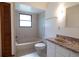 Well-lit bathroom with neutral tile, tub, vanity, and dark hardware, designed for relaxation at 3804 65Th E St, Bradenton, FL 34208