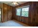 Bright bedroom with wood paneled walls, window, and tile flooring at 3804 65Th E St, Bradenton, FL 34208