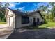 Side view of the home, featuring an attached two-car garage, windows with shutters, and well kept yard at 3804 65Th E St, Bradenton, FL 34208