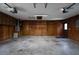 Attached garage featuring wood paneling, concrete floors and overhead storage at 3804 65Th E St, Bradenton, FL 34208