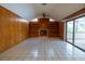 Living room features wood paneling, fireplace, tile flooring, built-in shelving, and sliding glass door at 3804 65Th E St, Bradenton, FL 34208