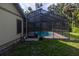 A screened-in pool area with a tranquil pool and tile decking, set against a backdrop of mature trees at 3804 65Th E St, Bradenton, FL 34208