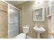 Bathroom with a glass door shower, pedestal sink, tile flooring, and modern fixtures at 444 Flamingo Dr, Apollo Beach, FL 33572