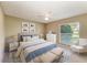 Staged bedroom with white and blue decor features a large window, ceiling fan, and carpeted floors at 444 Flamingo Dr, Apollo Beach, FL 33572