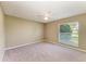 Neutral bedroom features a large window with natural light, carpeted floor, and ceiling fan at 444 Flamingo Dr, Apollo Beach, FL 33572