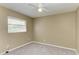 A simple, carpeted bedroom featuring a window with blinds and a ceiling fan at 444 Flamingo Dr, Apollo Beach, FL 33572