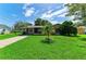 Charming single-story home featuring a lush green lawn and mature landscaping under a bright blue sky at 444 Flamingo Dr, Apollo Beach, FL 33572