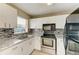 Bright kitchen with white cabinetry, modern backsplash, stainless steel appliances, and granite countertops at 444 Flamingo Dr, Apollo Beach, FL 33572