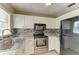 Updated kitchen features stainless steel appliances, modern backsplash, white cabinets, and granite countertops at 444 Flamingo Dr, Apollo Beach, FL 33572