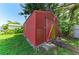 Exterior of the backyard red storage shed on a sunny day at 444 Flamingo Dr, Apollo Beach, FL 33572