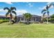 Lush green backyard with a screened-in pool area, featuring meticulous landscaping and mature palm trees at 4540 Terrazza Ct, Bradenton, FL 34211
