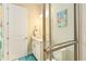 Bright bathroom featuring white cabinets, framed mirror, decorative flamingo art, and glass shower door at 4540 Terrazza Ct, Bradenton, FL 34211