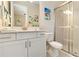 Bright bathroom with a glass-enclosed shower, white vanity, and coastal-themed decor at 4540 Terrazza Ct, Bradenton, FL 34211