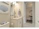 This half bath boasts a pedestal sink, a seashell painting and coastal decor in a bright, light space at 4540 Terrazza Ct, Bradenton, FL 34211