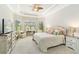 A bright bedroom boasts a trey ceiling with fan, a desk, neutral walls, and plush carpet at 4540 Terrazza Ct, Bradenton, FL 34211