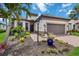 Beautiful home exterior with manicured landscaping, vibrant flowers, brick paver driveway, and attached two-car garage at 4540 Terrazza Ct, Bradenton, FL 34211