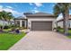Beautiful front exterior of home with a tile roof, two-car garage, and beautifully landscaped front yard at 4540 Terrazza Ct, Bradenton, FL 34211