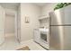 Well-equipped laundry room with modern washer, dryer, and stainless steel refrigerator at 4540 Terrazza Ct, Bradenton, FL 34211