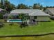 Aerial view showcasing a pool, lakefront backyard and lush lawn at 4733 Spring Meadow Ln, Sarasota, FL 34233