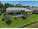 Aerial view of the backyard showing pool and tropical landscaping next to a beautiful lawn and canal at 4733 Spring Meadow Ln, Sarasota, FL 34233