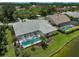 Aerial view of the home's backyard, featuring a screened lanai, pool, and lush tropical landscaping at 4733 Spring Meadow Ln, Sarasota, FL 34233