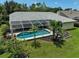Aerial view of the home's private backyard with a screened lanai, pool, and lush landscaping at 4733 Spring Meadow Ln, Sarasota, FL 34233