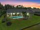 Aerial view of a backyard featuring a screened-in pool, lush lawn, mature landscaping, and a serene pond at 4733 Spring Meadow Ln, Sarasota, FL 34233