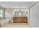 Bathroom with dual sinks, mirrors, a soaking tub, and neutral tile flooring at 4733 Spring Meadow Ln, Sarasota, FL 34233