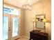 Inviting foyer with decorative glass doors, stylish chandelier, and elegant furnishings at 4733 Spring Meadow Ln, Sarasota, FL 34233